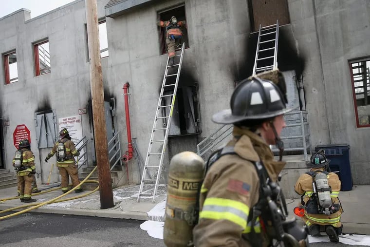 Volunteer firefighters participate in a rowhome fire training exercise at the Chester County Public Safety Training Campus in Coatesville. TIM TAI / Staff Photographer