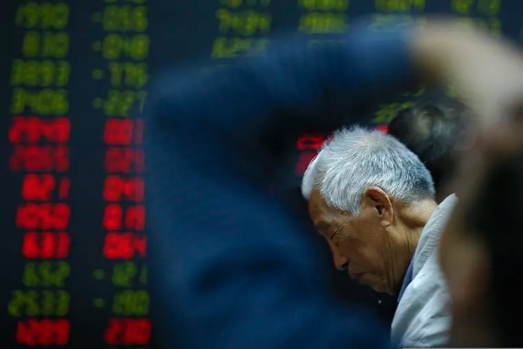 In this Oct. 24, 2018, photo, an investor reacts as he and investors monitor stock prices at a brokerage house in Beijing. Asian stocks were mostly lower with light trading on Monday, Dec. 24, as a Wall Street slump and a partial U.S. government shutdown stemmed holiday cheer.(AP Photo/Andy Wong)