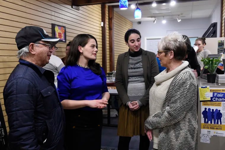Pa. Rep.-elect Elizabeth Fiedler (second from left) and her field director, Katie Longo, talk to constituents during a holiday open house at Fiedler's office at 2400 S. 9th Street.