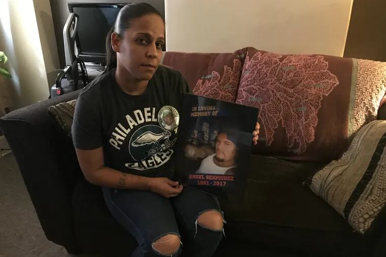 Jessica Vega holds a framed photo of Angel Bermudez in her North Philadelphia home Wednesday. Bermudez, 36, was fatally shot Oct. 11 in his car at D and Westmoreland Streets in Kensington.