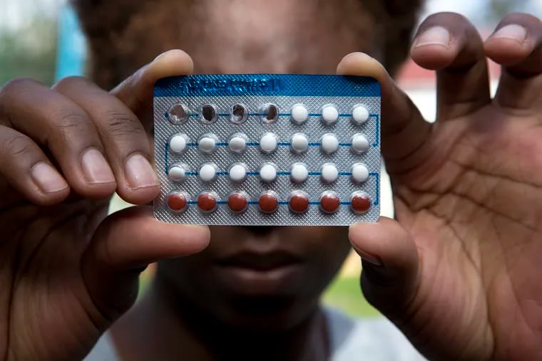 A woman holds a packet of contraceptive pills,  in Harare, Thursday, April 9, 2020. Lockdowns imposed to curb the coronavirus’ spread have put millions of women in Africa, Asia and elsewhere out of reach of birth control and other reproductive health needs. (AP Photo/Tsvangirayi Mukwazhi)