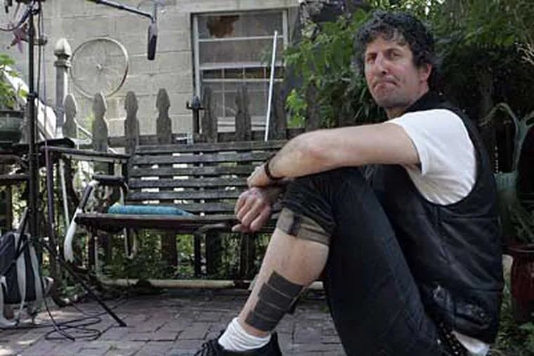 Stewart Ebersole shows off his Black Flag tattoo in the Rocket Cat Cafe Garden. (Bonnie Weller / Staff Photographer)