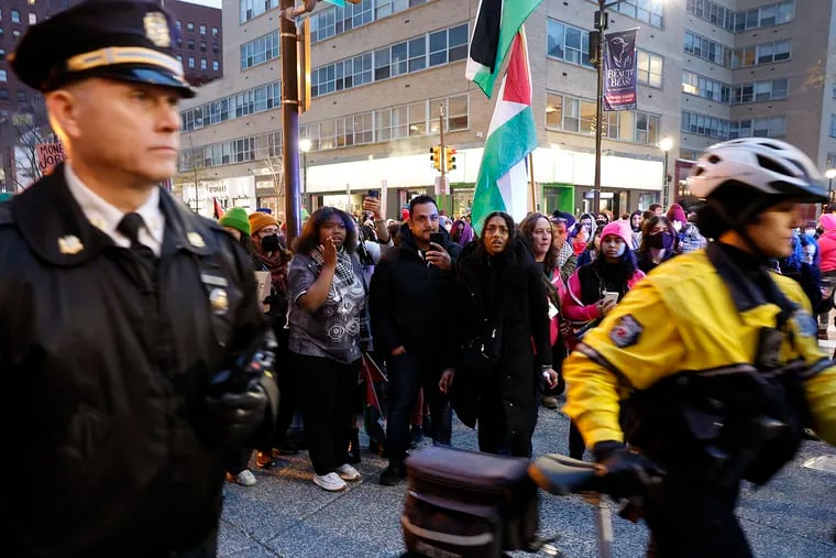 Pro-Palestinian supporters watch the Philadelphia Police during a cease-fire rally near Rittenhouse Square in Center City on Saturday.