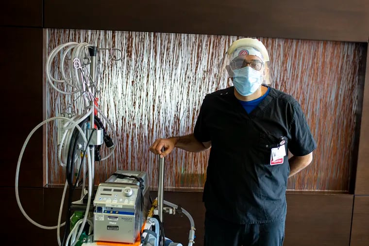 Nitin Puri, co-director of critical care services at Cooper University Hospital, poses with an extracorporeal membrane oxygenation (ECMO) machine.  The machine oxygenates the blood and is used for the sickest patients with coronavirus.