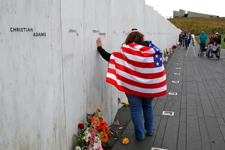 Chrissy Bortz of Latrobe, Pa., pays her respects at the Wall of Names at the Flight 93 National Memorial in Shanksville, Pa. after a Service of Remembrance Tuesday, Sept. 11, 2018, as the nation marks the 17th anniversary of the Sept. 11, 2001 attacks. The Wall of Names honor the 40 people killed in the crash of Flight 93.