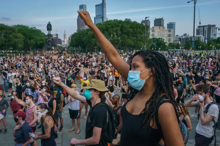 Protestor Iris Bowen raises her fist, front center, along with with many other protestors gathered at the Art Museum steps, in remembrance of George Floyd, in Philadelphia, June 04, 2020.