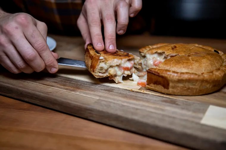 Dan Giorgio, 28, of South Philadelphia, Operations Assistant at Primal Supply Meats, cuts a slice of guinea hen pot pie. The pie includes guinea hen, mirepoix, garlic, wine, butter, flour, stock, milk, salt and spices.