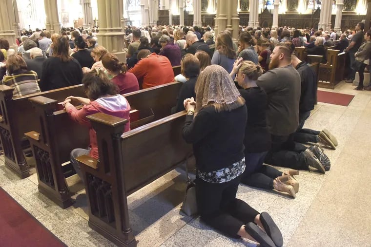 People knelt behind the pews at St. Paul Cathedral as Bishop David Zubik delivered Mass for St. Pio of Pietrelcina, also known as Padre Pio, in the Oakland section of Pittsburgh Tuesday, May 9, 2017. Saint Pio was a Franciscan Capuchin priest and his father worked in New Castle, Pa. and helped pay for his son's education for the priesthood.