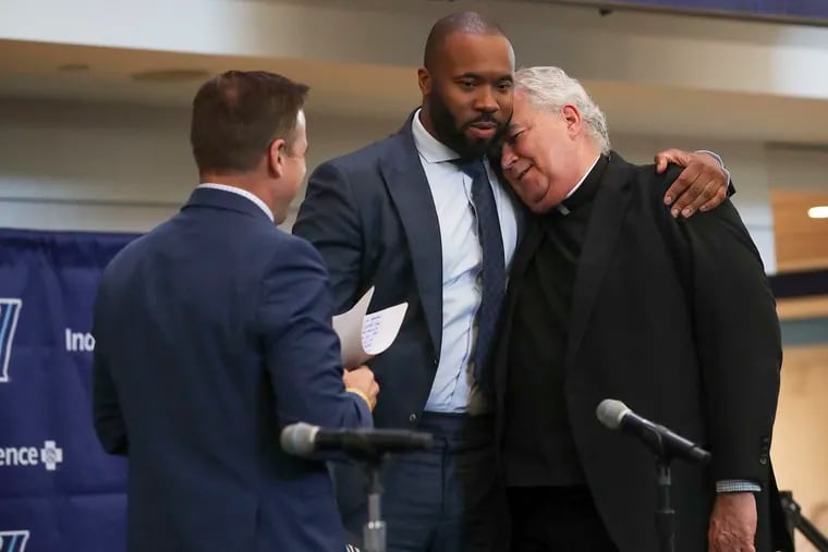 New Villanova coach Kyle Neptune hugs president Peter M. Donohue during a press conference introducing him.