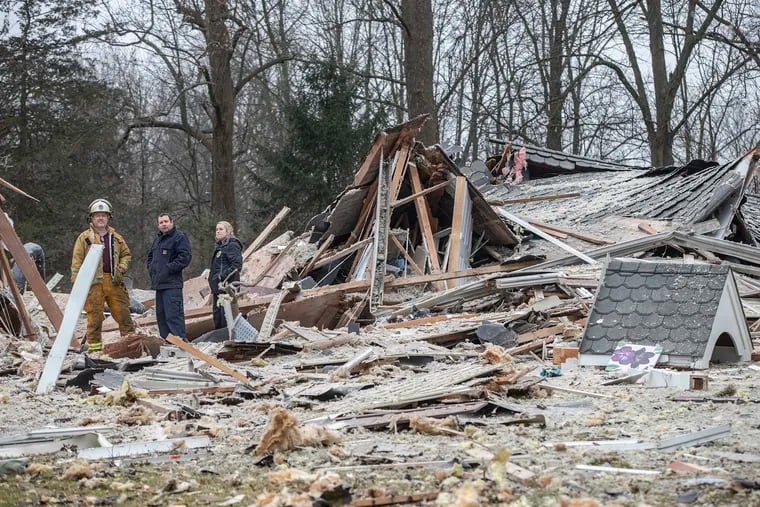 Buckingham Township Fire Marshal Jim Kettler, left, along with two members of the Bucks County Fire Marshal's office, center and right, stand amid the wreckage that once was a home on Biddeford Circle that was destroyed by an explosion early Tuesday morning.