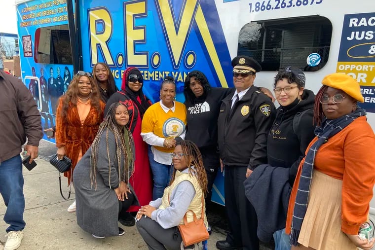 A group of community well-wishers joined the Rev. Michelle Anne Simmons (center, in yellow T-shirt), executive director of Why Not Prosper, as she cut the ribbon on the reentry group's first mobile social service office called the R.E.V., or Rolling Engagement Van.