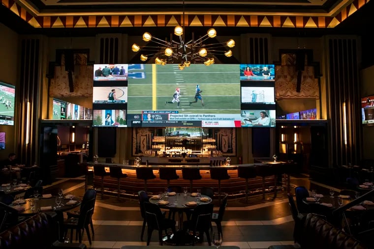 A 9- by 25-foot TV hangs over the bar in the Big Game Room inside of Bankroll, a sports bar in the space where Boyd Theater was, at 1910 Chestnut St.
