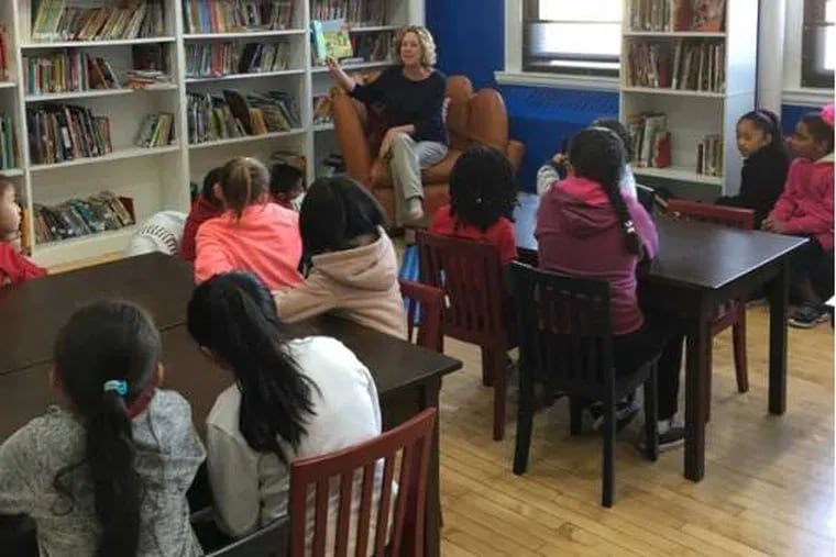 Terri Akman reads to a first-grade class is the Vare-Washington school library donated by Ryan Howard.