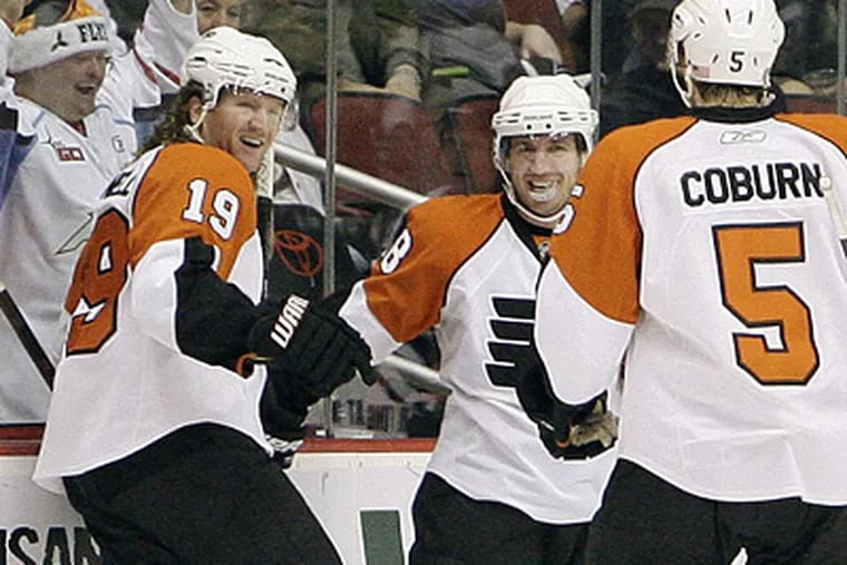 Scott Hartnell, left, celebrates his goal with teammates Mike Richards, middle, and Braydon Coburn in the second period of the Flyers' 3-1 loss to Phoenix. (AP Photo/Ross D. Franklin)