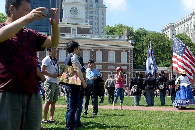 Tourist on Independence Mall snap photos during a Flag Day parade from the National Constitution Center to Independence Hall June 14, 2015. (TOM GRALISH / Staff Photographer)