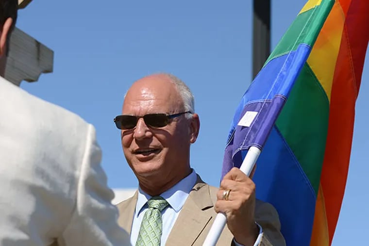 Atlantic City Mayor Don Guardian holds the rainbow flag before it was raised at Park Place on the Atlantic City Boardwalk on Monday, June 16, 2014.  (Andrew Thayer/Staff Photographer)
