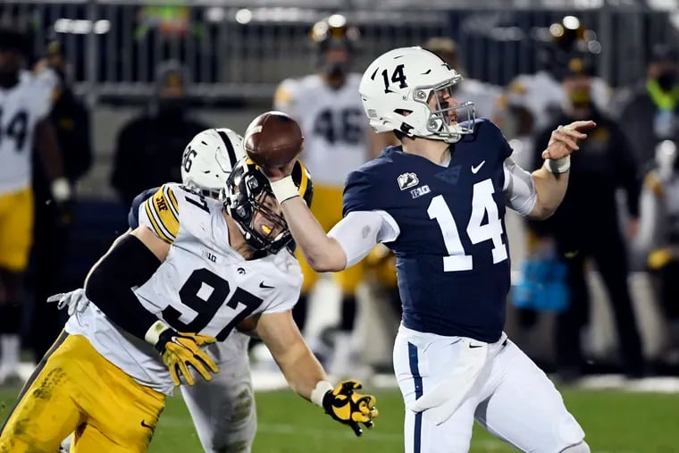 Penn State quarterback Sean Clifford throwing a third-quarter touchdown pass as Iowa lineman Zach VanValkenburg gets close on Nov. 21.