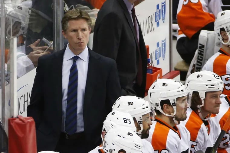 Coach Dave Hakstol, behind the Flyers' bench.