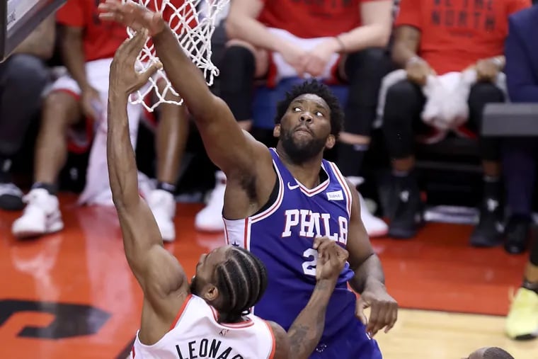 Kawhi Leonard, left, of the Raptors goes up for a shot against Joel Embiid of the Sixers during the 3rd quarter of their NBA playoff game at the Scotiabank Arena in Toronto on April 27, 2019.