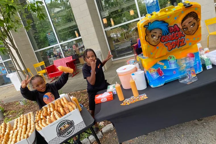 Eight-year-old Chase Anderson (right) runs Da Cooler Boyz, a water ice business, along with his brother Sebastian (left) and his mom Breonna.