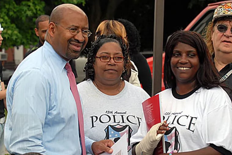 Mayor Nutter poses for pictures with the family of a girl who was raped in Kensington. The family hosted a barbeque for Nutter, police officers, and the vigilantes who stopped and beat a man who police say is a suspect in the case.(Ron Tarver / Staff Photographer)