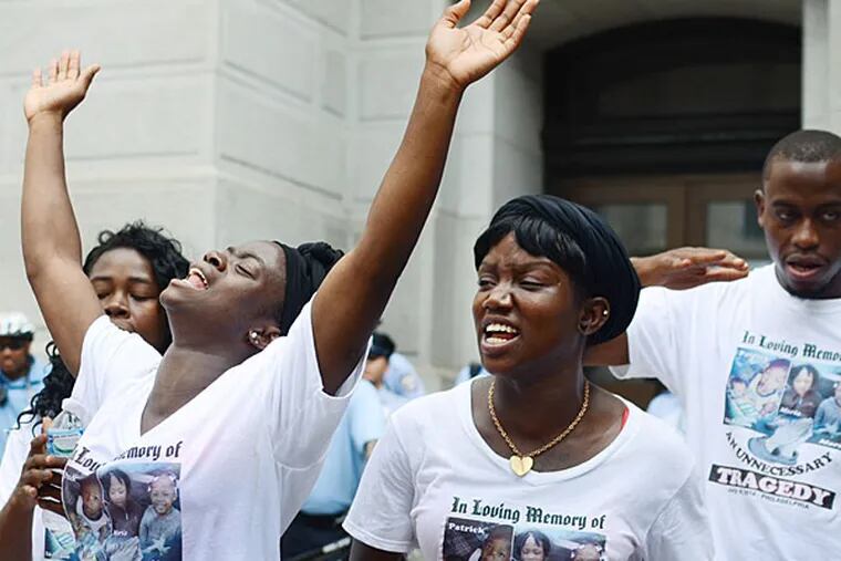 Fefe Davis, left, chants in front of City Hall as part of a protest over the city's response to the deadly West Philadelphia fire that killed four children.  Andrew Thayer / Staff Photographer