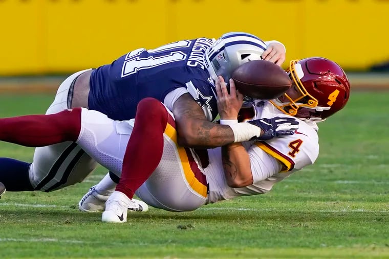Washington Football Team quarterback Taylor Heinicke (4) fumbling the ball as he was sacked by Dallas Cowboys outside linebacker Micah Parsons during the first half Sunday in Landover, Md. Dallas recovered the ball and scored a touchdown on this play.