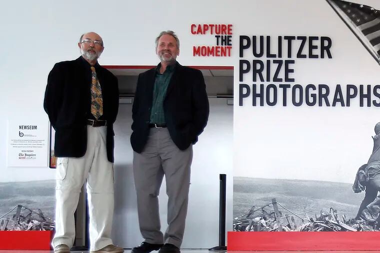 Local Pulitzer Prize winning photographer Tom Kelly III, left, and Tom Gralish pose outside the new exhibit at the National Constitution Center titled "Capture the Moment: The Pulitzer Prize Photographs" in Philadelphia. Their work is featured in the show.