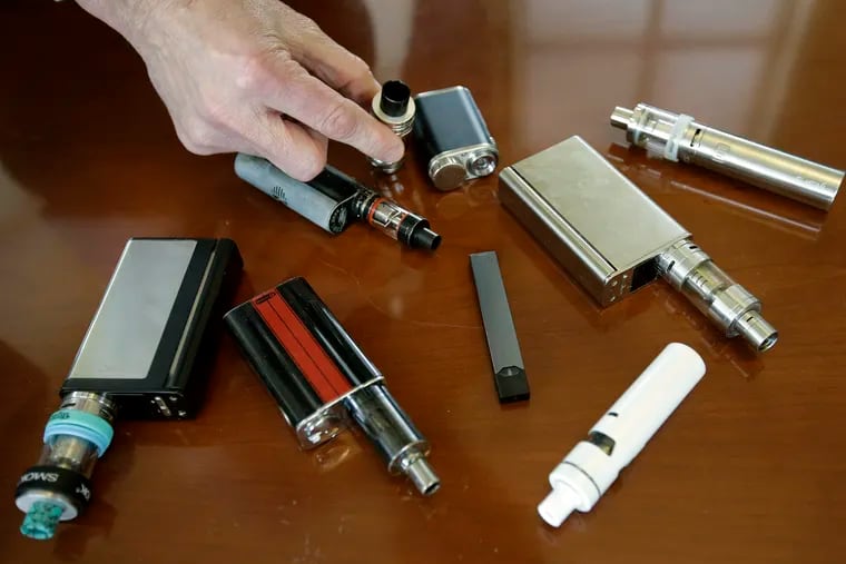 In this 2018 file photo, a high school principal displays vaping devices that were confiscated from students in such places as restrooms or hallways at the school in Massachusetts. (AP Photo/Steven Senne)