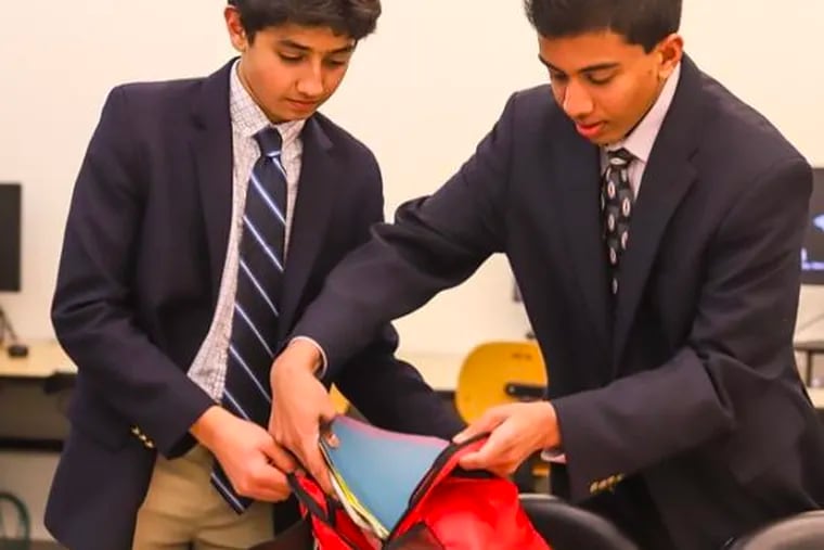 Daniel Adibi (left) and Advaith Kollipara put together a bundle of school supplies to be donated to a refugee student.
