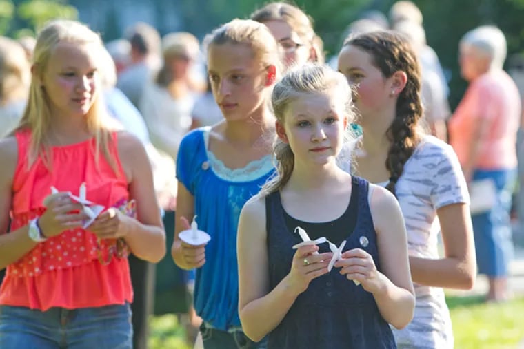 Phoebe Berner, 13, and friends pass out candles during memorial service for her father, Craig Berner, an off-duty Moorestown officer who was killed in a motorcycle accident. Photos taken during memorial service at Memorial Park, Moorestown, June 16, 2014. (DAVID M WARREN/Staff Photographer)