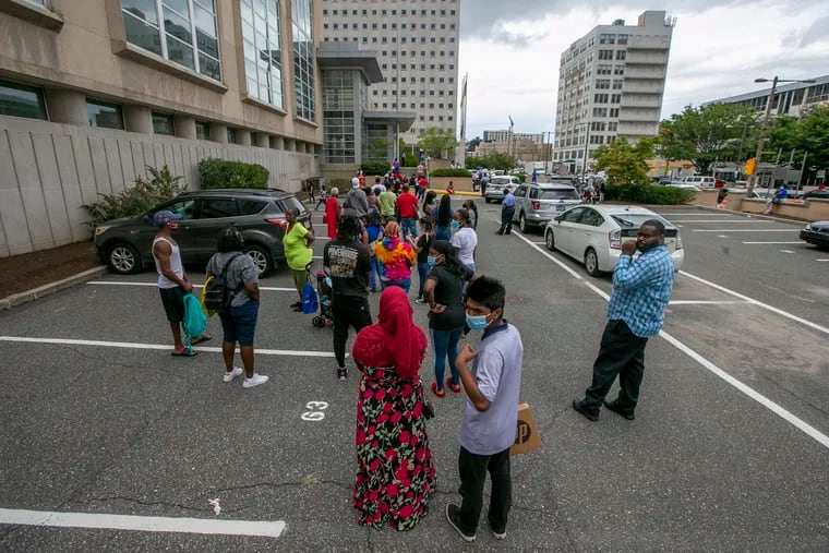 A long line in the parking lot of the Philadelphia School District building as people wait to pick up laptops in advance of the first day of school for 125,000 students.