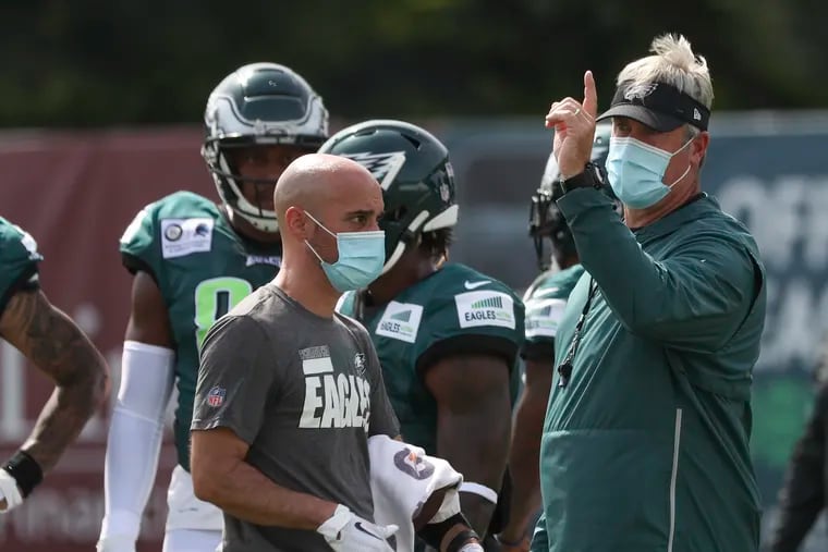 Coaches, such as Doug Pederson (right), and other team personnel will wear masks on the sideline this season.