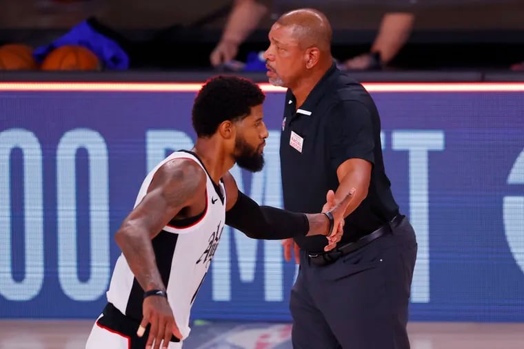 Doc Rivers celebrates with Paul George (13) after a win against the Dallas Mavericks in Game 3 of the Western Conference first-round playoff series.