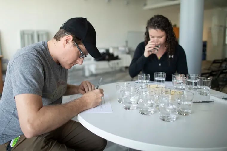 Barry Hosten (left), Brewery manager at Flying Fish Brewing Company and Beth MacKenzie (right), water sommelier and certified brew master, participate in a water taste test at the Philadelphia Inquirer building on May 21, 2019.