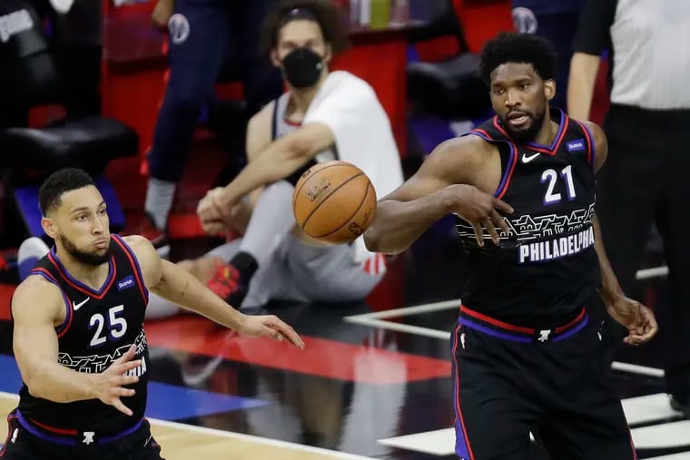 Sixers guard Ben Simmons and center Joel Embiid going after a loose ball against the Washington Wizards during Game 1.