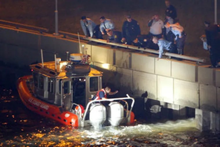 A Coast Guard boat assists in the search for a suspect in the Schuylkill last night after a Philadelphia cop was shot.