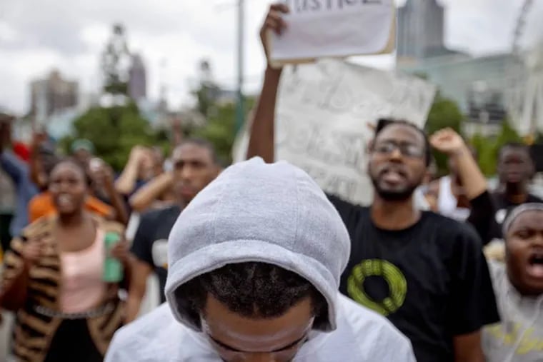 A demonstrator wears a hoodie during a protest the day after George Zimmerman was found not guilty in the 2012 shooting death of teenager Trayvon Martin, Sunday, July 14, 2013, in Atlanta. (AP Photo/David Goldman)
