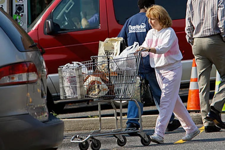 A shopper navigating the congested parking lot at the Whole Foods Market on Callowhill Street. The planned flagship would replace the Callowhill store.