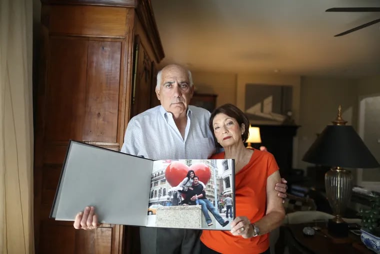 Ellen Greenberg's parents, Joshua and Sandra, hold a scrapbook of their daughter in their Harrisburg home.