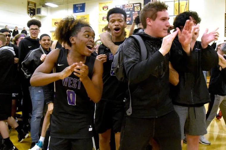 Cherry Hill West's Richey Hampton, left; celebrates with teammates and fans after upsetting Moorestown, 63-54, Friday night in the South Jersey Group 3 semifinals.  (April Saul / For The Inquirer)