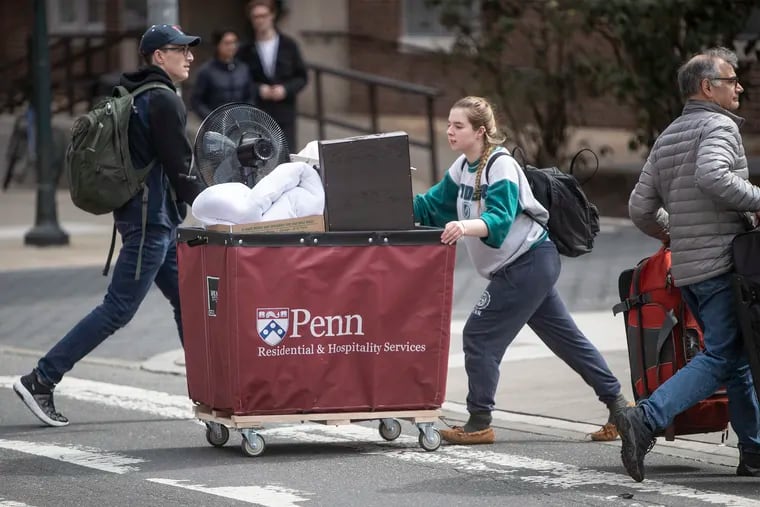 Katie Murray, a University of Pennsylvania freshman from Cleveland, Ohio, pushes her hamper filled with the contents of her dorm room across Spruce Street last March in preparation for the trip home after Penn suspended campus classes due to the coronavirus.