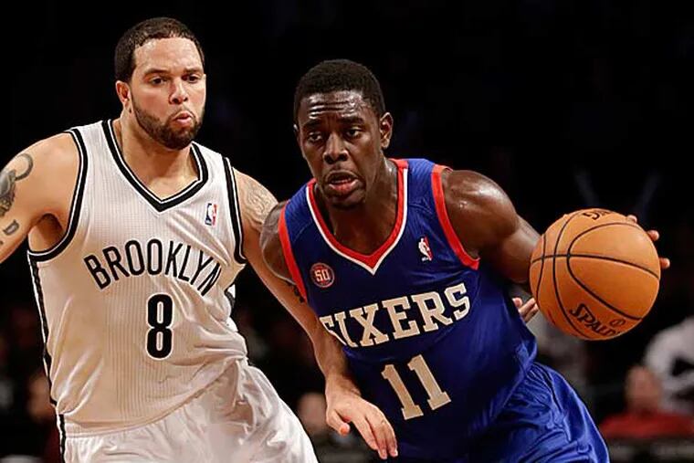 Philadelphia 76ers' Jrue Holiday, right, moves around Brooklyn Nets' Deron Williams during the second half of an NBA basketball game at the Barclays Center Sunday, Dec. 23, 2012 in New York. The Nets beat the 76ers 95-92. (Seth Wenig/AP)