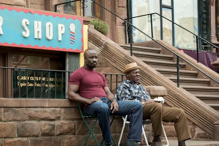 In "Luke Cage," Mike Colter (left) plays the bulletproof title character, who lies low at Pop's Barbershop after the events of "Jessica Jones." Frankie Faison plays Pop. MYLES ARONOWITZ / Netflix