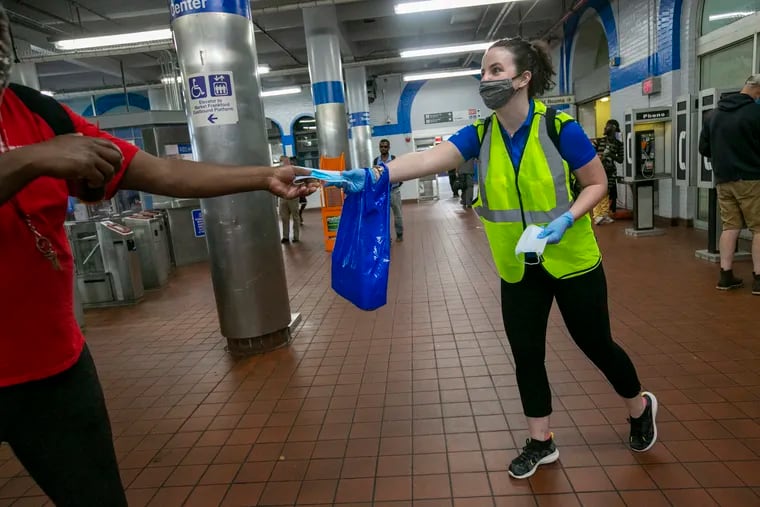 Jessica Mangold, project manager with SEPTA hands out masks to riders at 69th Street Station in Upper Darby, PA on Thursday, August 13, 2020.