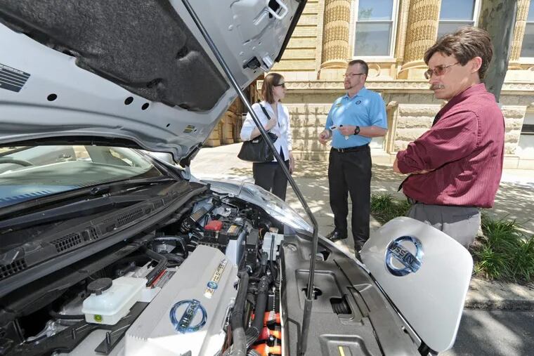 Participants at a 2012 Pennsylvania Public Utilities Commission conference on alternative fuel vehicles at Drexel University look over the engine of a Nissan Leaf. Nissan is discounting the electric vehicle ahead of the introduction of a new model.