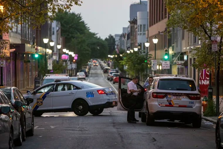 Philadelphia police officers process a crime scene in July 2021 on South Street near Broad, where a Chevrolet Malibu stolen by Kareem Welton was abandoned after he fatally struck a pedestrian nearby.
