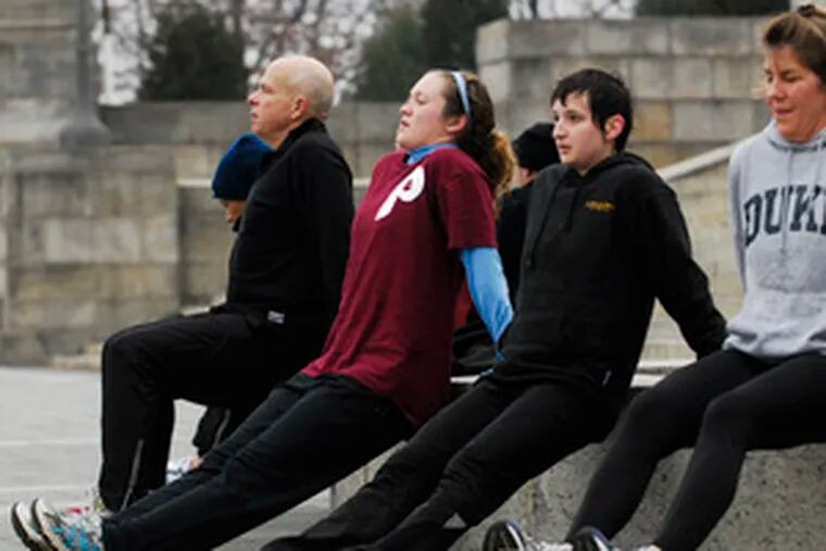 Doing tricep dips at the Art Museum are (from left) Lou Rossman, Nancy Villante, Maggie Hochberg and Chris Costello. Platoon, based on the Main Line, charges participants $80 a month for the exercise program.