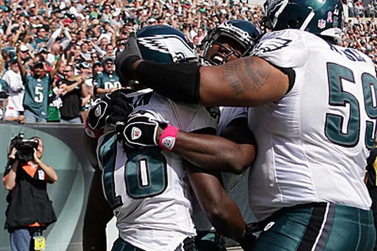 WR Jeremy Maclin is embraced by teammates Jason Avant and Nick Cole. (David Maialetti / Staff Photographer)