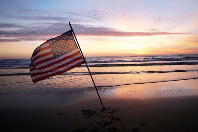 An American flag is placed in the sand of Omaha Beach in Normandy to honor the troops who participated in the invasion. (AP Photo/Thibault Camus)